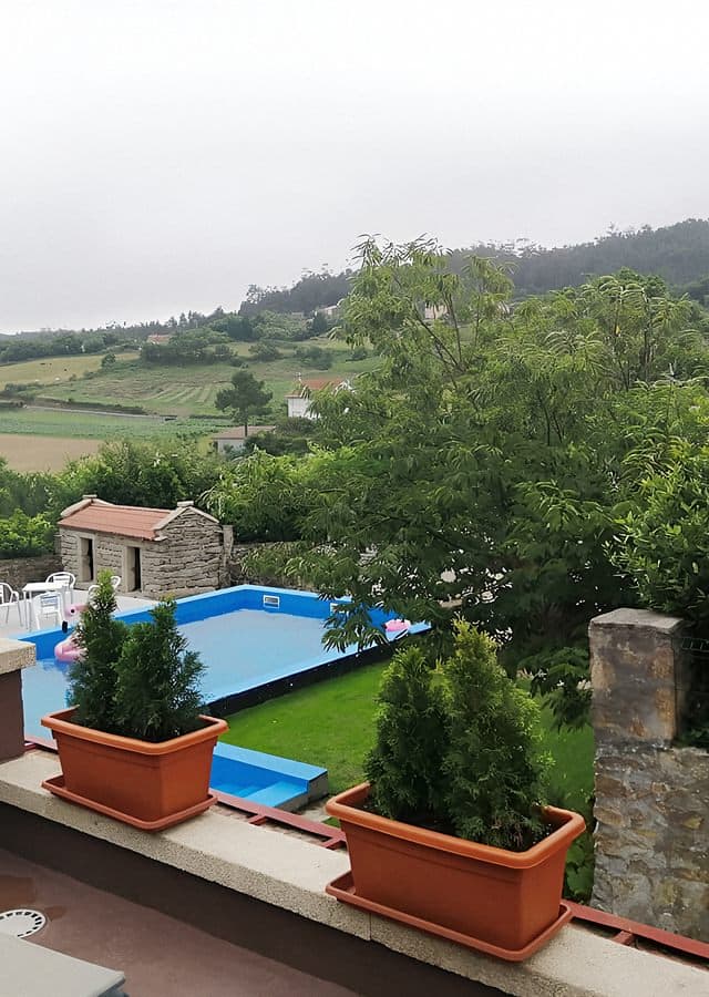 Piscina de Casa O Gurés en Muxía, con jardín y macetas